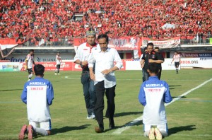 Presiden Jokowi berlari seusai melakukan kick off turnamen sepakbola Piala Presiden, di Gianyar, Bali, Minggu (30/8)