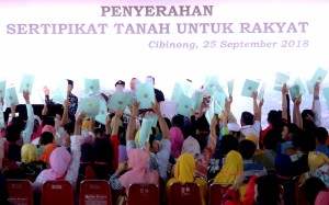 Presiden Jokowi menghitung sertifikat yang diterima warga Bogor, di Lapangan Stadion Pakansari. Bogor, Jabar, Selasa (25/9) pagi. (Foto: Rahmat/Humas)