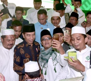 Presiden Jokowi melayani permintaan selfi saat hadir pada Halalbihalal dan Silaturahim dengan Solidaritas Ulama Muda Jokowi (Samawi), di SICC, Bogor, Jabar, Selasa (10/7) malam. (Foto: Setpres)