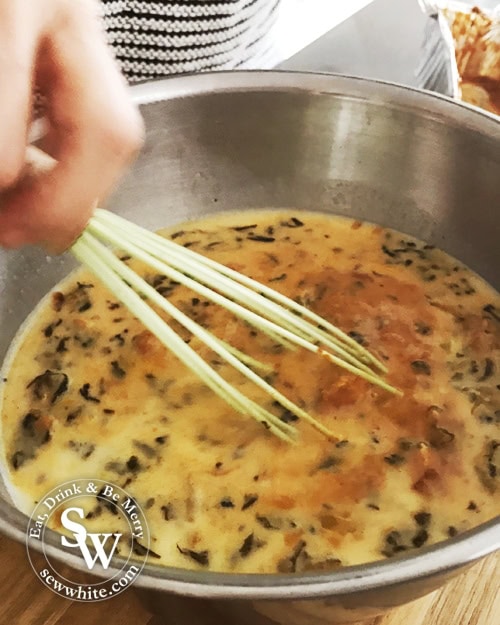 whisking up the egg and curry mix to make omelette