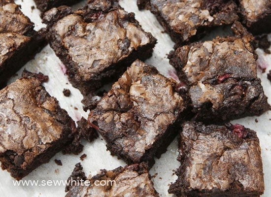 Close up of black forest brownies. Crispy brownies with lovely top and squidgy centre topped with cherries, raspberries and blackberries.