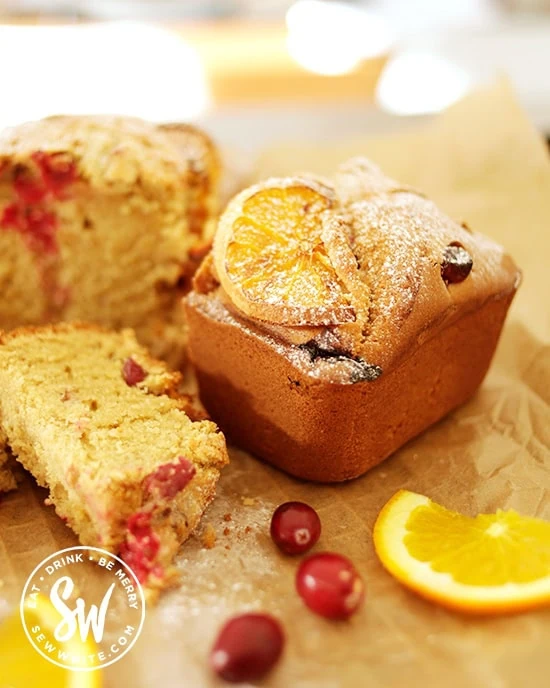 cranberry and orange loaf surrounded by fresh cranberries and orange slices