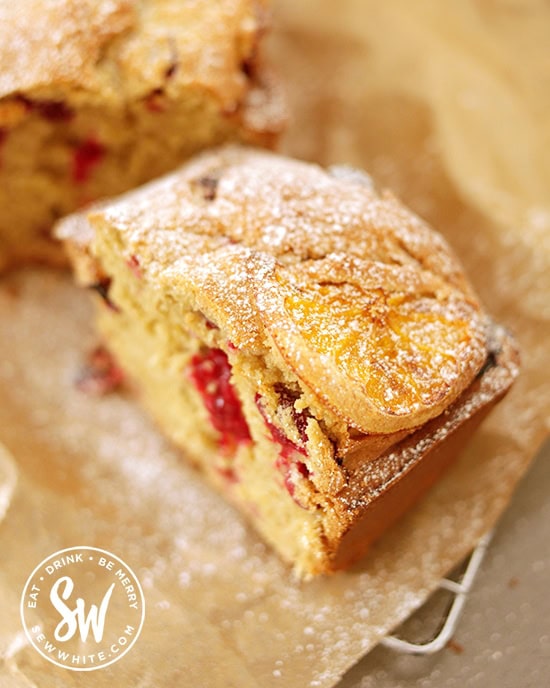 A slice of golden baked cranberry and orange loaf