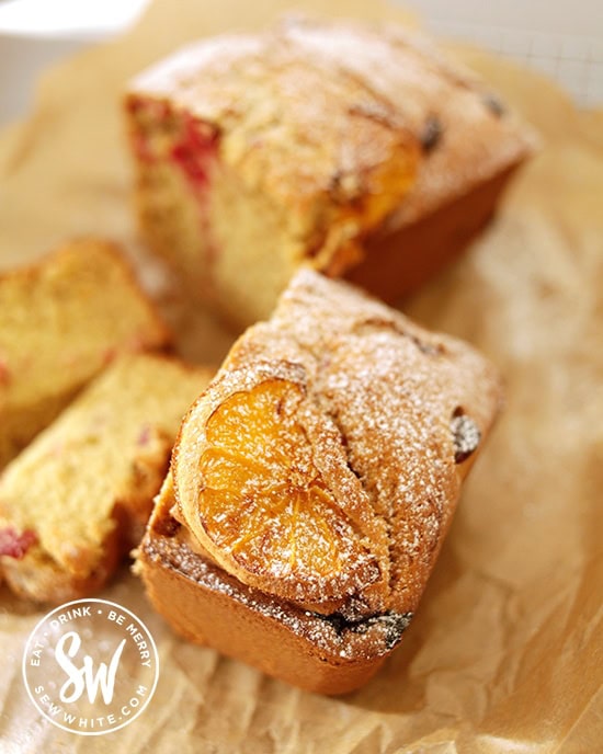 Golden caramelised orange slice on top of a cake dusted with icing sugar.