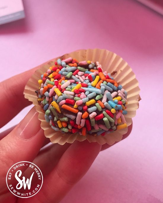 Brightly coloured sprinkles on chocolate truffles