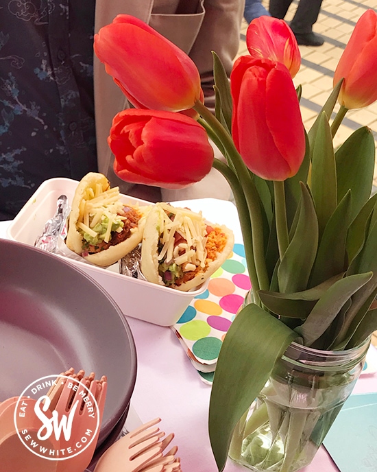 Street food at the Love Wimbledon market. A table with red tulips.
