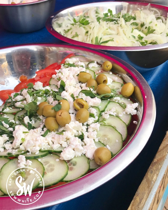 A big greek salad with olives and feta cheese.