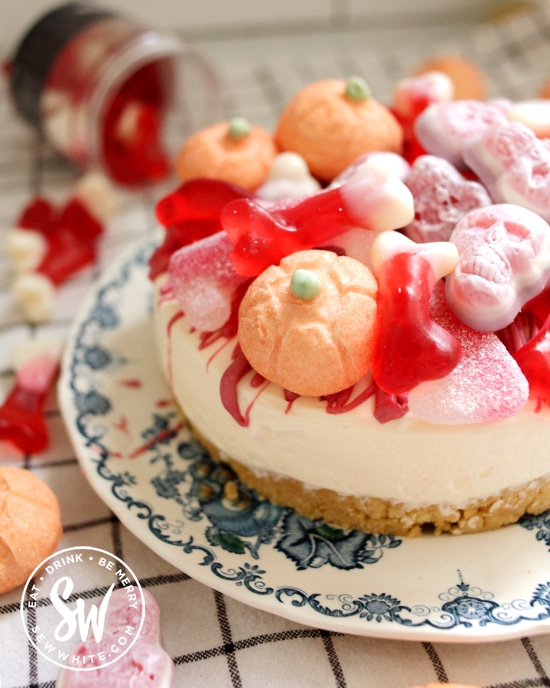 Easy No Bake vanilla cheesecake covered with skulls sweets and marshmallow pumpkins