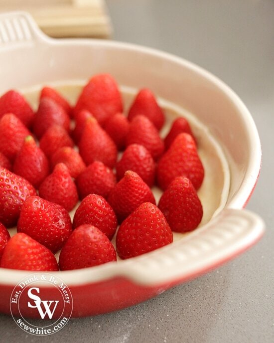 Red le creuset dish with bright red strawberries tart inside. Balsamic Vanilla Strawberry Tart