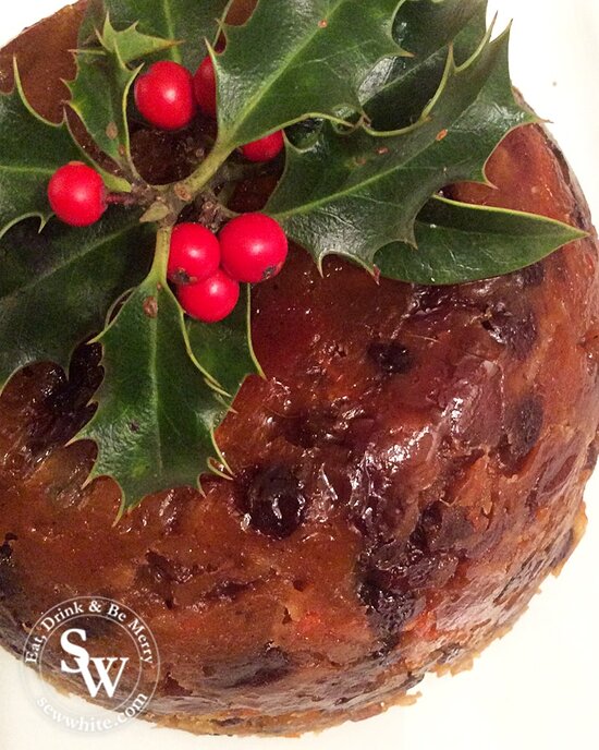 An English traditional Christmas pudding decorated with a sprig of holly.