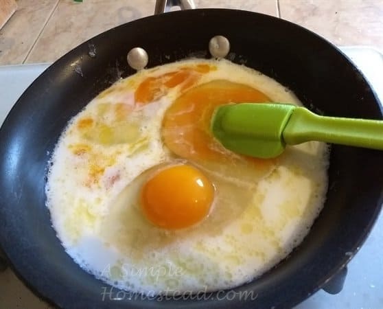 scrambled eggs cooking in a saucepan