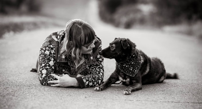 Hundefoto mit Frauchen im Freien in Schwarz Weiss Frauchen und Hund schauen sich auf einem Weg liegend an Canon EOS R6 & RF 85mm f/1.2L USM