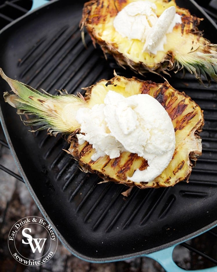 BBQ Grilled Pineapple served on the teal Le Creuset grill pan on the camp fire with white chocolate ice cream on top.