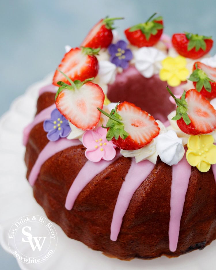 Strawberry Prosecco Cake in a Kugelhopf shape from Le Creuset. Pink icing, baby meringues and fresh strawberries.