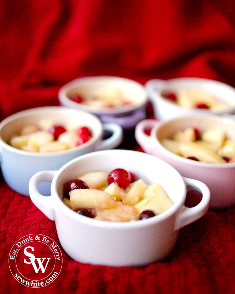 Petite Le Creuset casseroles filled with softened apple and fresh cranberries. Using up left over cranberries. A delicious apple and cranberry crumble