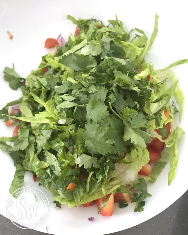 cilantro being added to the fish taco salsa