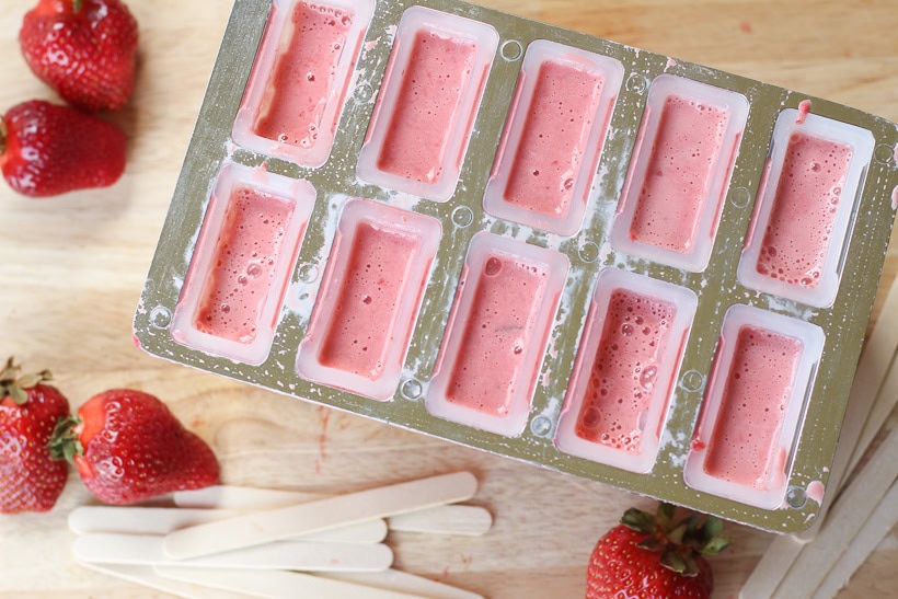 Keep cool this summer with these healthy Strawberries and Cream Popsicles. Kids young and old will love this healthy summer snack recipe. These strawberry frozen treats won't last long. #popsicles #healthypopsicles #strawberrypopsicles #popsiclerecipe
