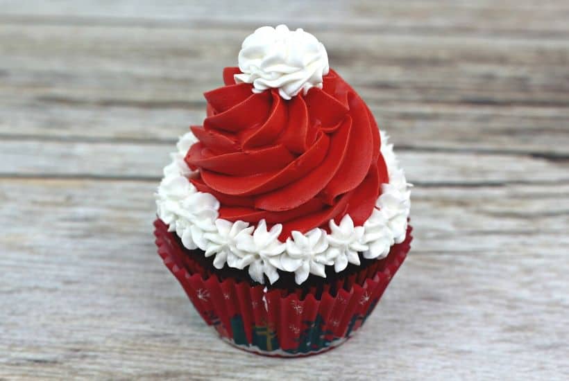 Make this Christmas a Disney Christmas. These adorable Mickey Mouse Santa Cupcakes are the perfect holiday Disney snack to celebrate Christmas. This Disney dessert is so easy and festive. Add a cute Mickey Santa hat to these decorated Christmas cupcakes. #disneysnack #christmascupake #disneyfood