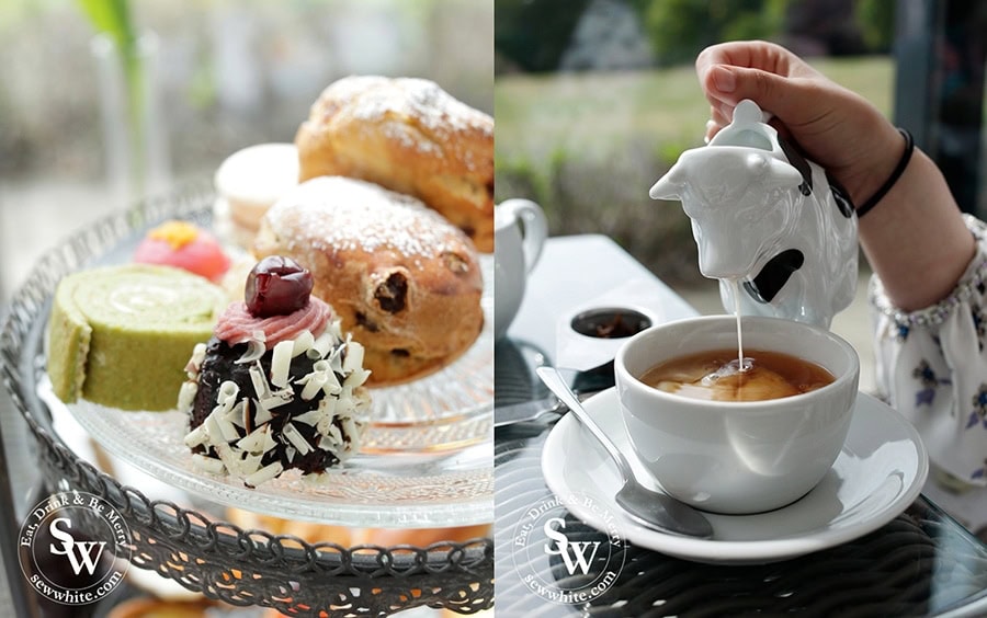 A cow shaped milk jug perfect for afternoon tea along side a range of delicious sweet patisserie pieces.