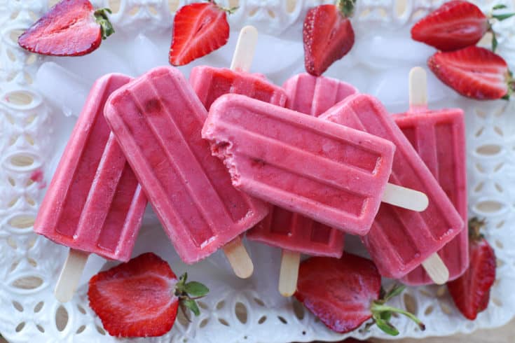 Keep cool this summer with these healthy Strawberries and Cream Popsicles. Kids young and old will love this healthy summer snack recipe. These strawberry frozen treats won't last long. #popsicles #healthypopsicles #strawberrypopsicles #popsiclerecipe