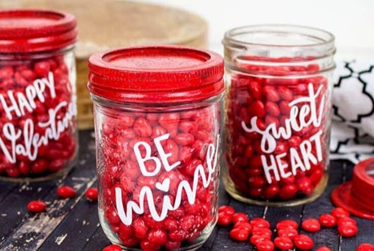 Share some sweetness this Valentine's Day. These Cricut Valentine Candy Mason Jars are a great gift idea for teachers, family and friends. This is an easy Valentine Craft idea to make with your Cricut Machine. This Cricut craft project is a perfect way to celebrate Valentine's Day. #cricutcraft #masonjars #valentinesday #valentinecraft