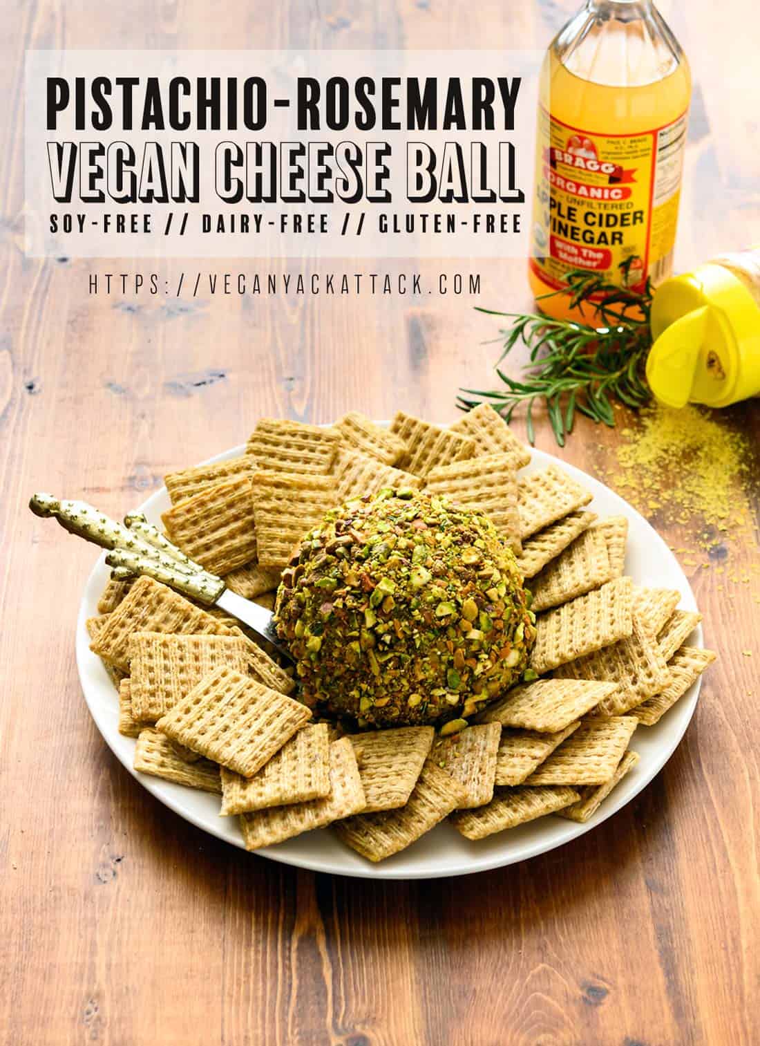 Picture of pistachio-rosemary cheese ball on a plate surrounded by crackers