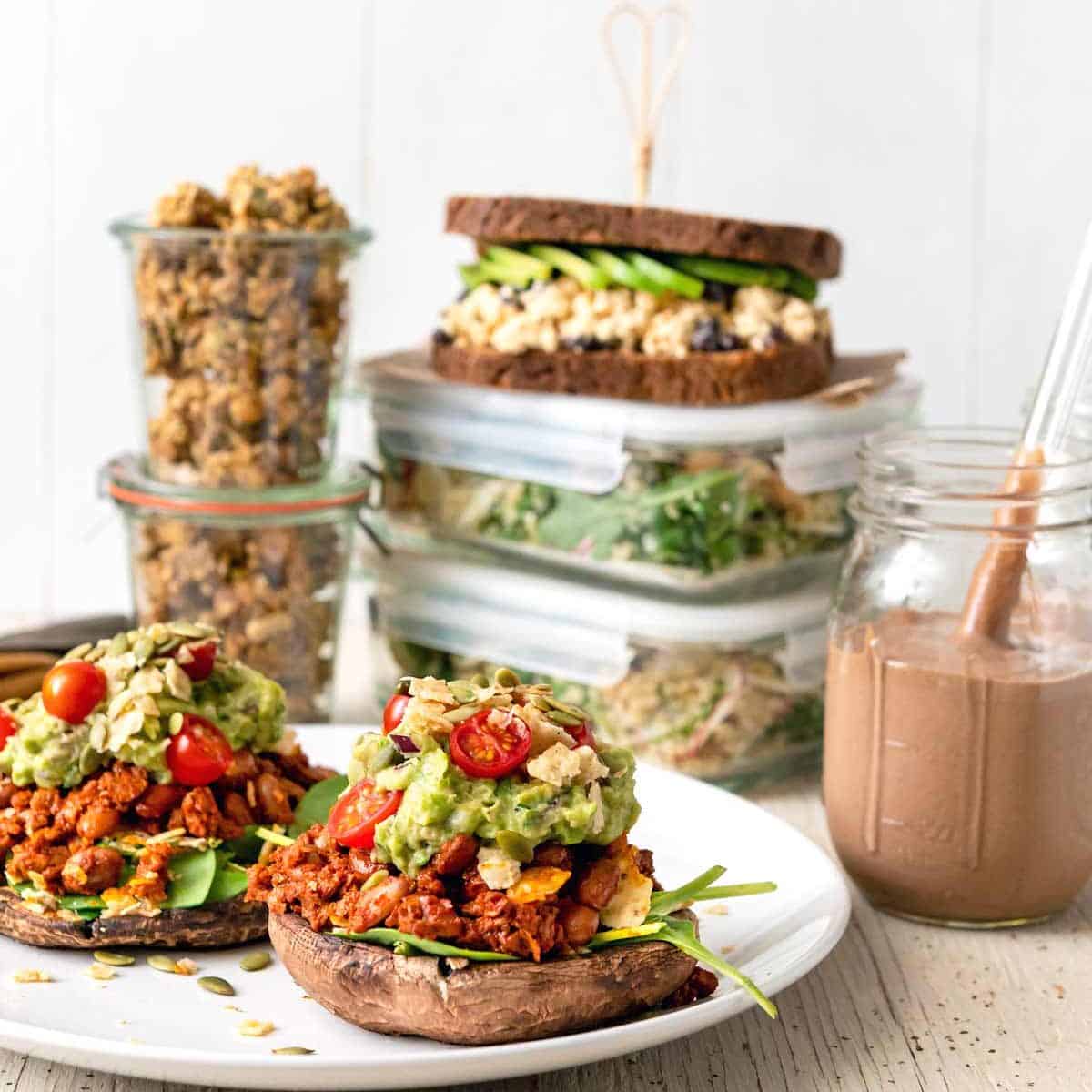 Image of multiple dishes for a High-Protein Vegan Meal Prep for two menu, with stuffed mushrooms in the foreground