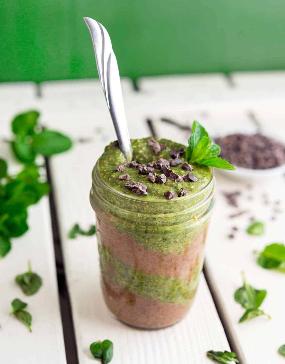 Image of Mint Chocolate Chia Parfait in a small jar on a white wood tabletop