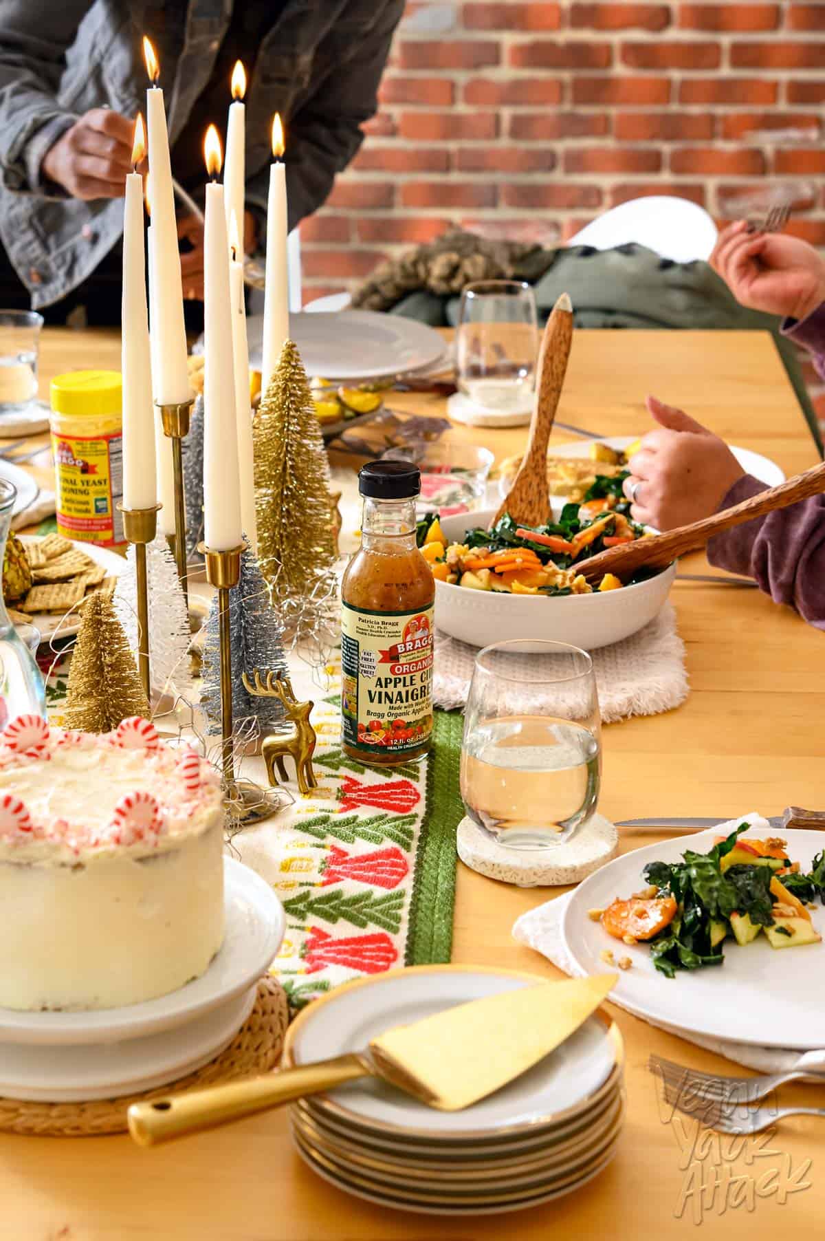 Image of an ultimate vegan holiday dinner spread with table runner and dishes, including salad and cake