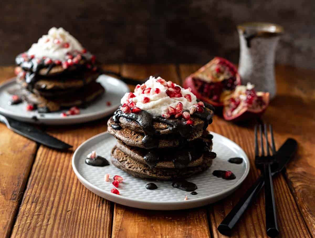 These Spooky Buckwheat Pancakes are eye-catching and delicious! Fluffy pancakes drizzled with a sweet black sesame sauce and topped with pomegranates, what more could you want? #Vegan #nutfree #glutenfreeoption #soyfree #halloween #veganrecipes