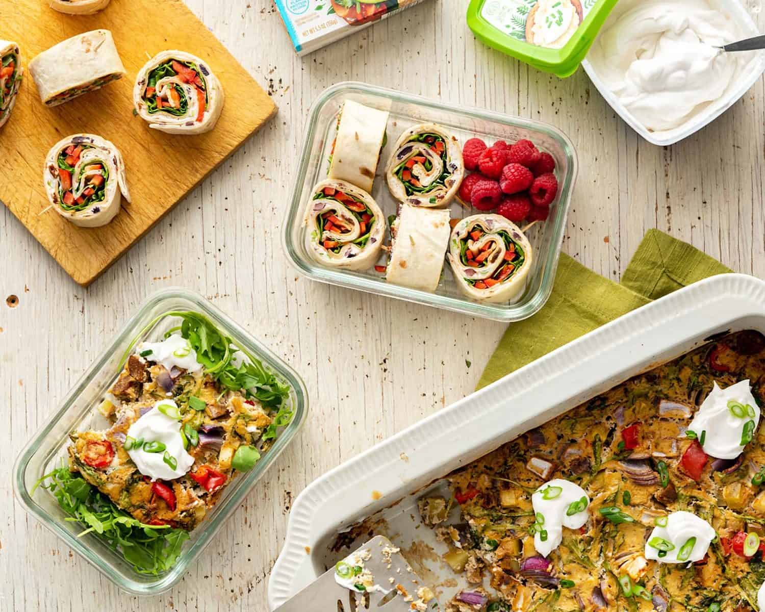 An image of a large casserole, with lunch roll-ups next to it, in meal prep containers