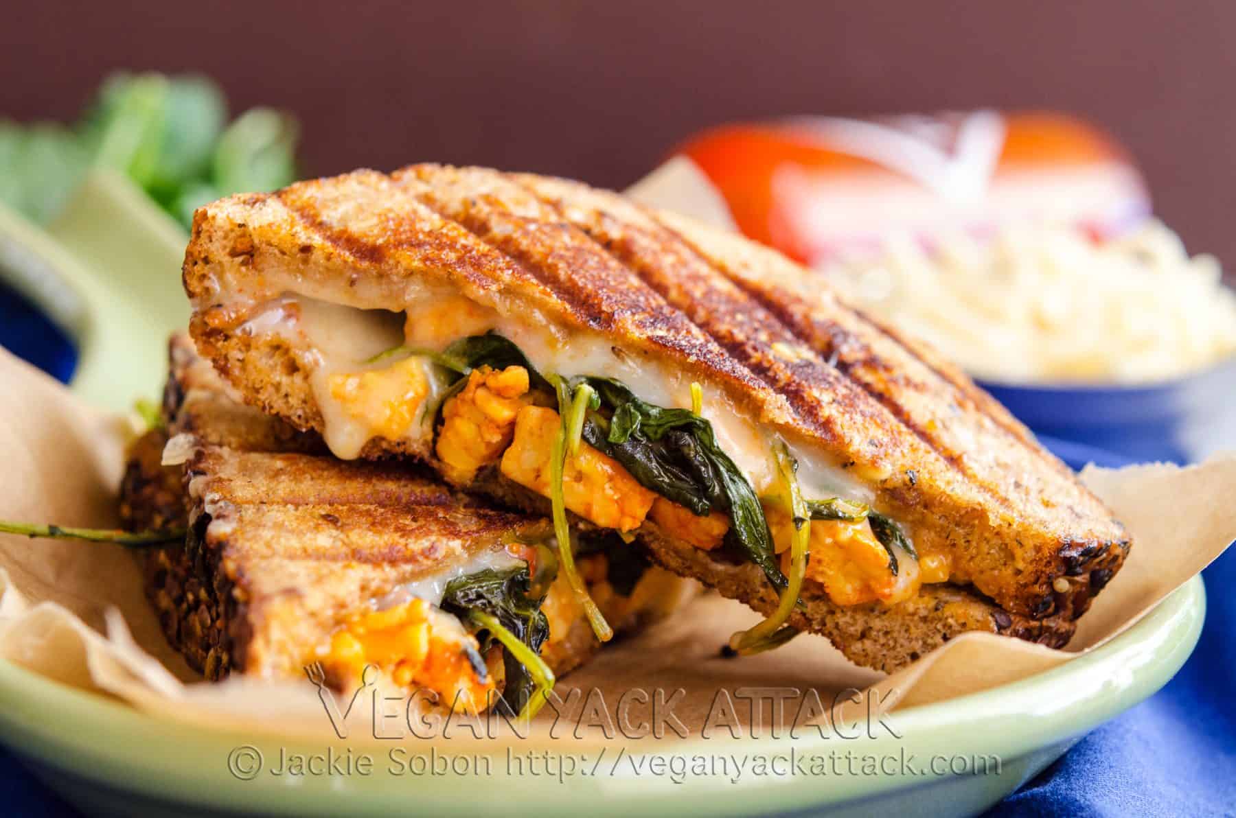 An nontraditional Grilled Buffalo Tempeh Mozzarella Sandwich, complete with spicy tempeh, kale, and melty vegan mozzarella.