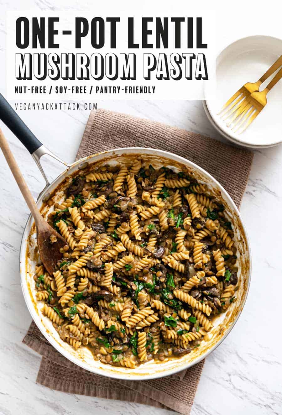 Image of one-pot lentil mushroom pasta in a large pan sitting on a towel