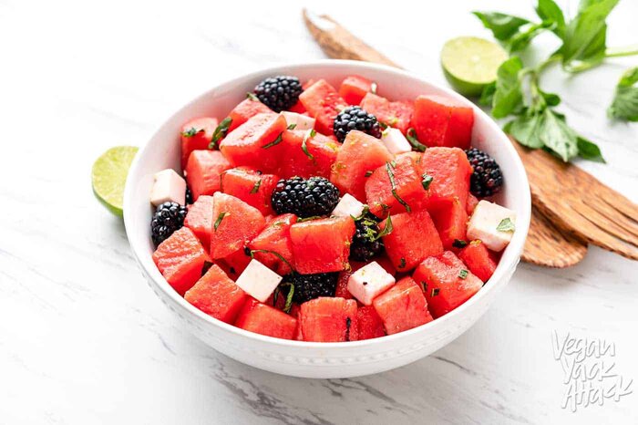Watermelon Blackberry Feta Salad in a large white bowl with wooden tongs