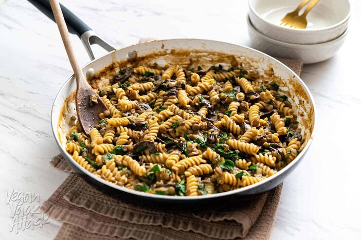 Image of one-pot lentil mushroom pasta in a large pan sitting on a towel