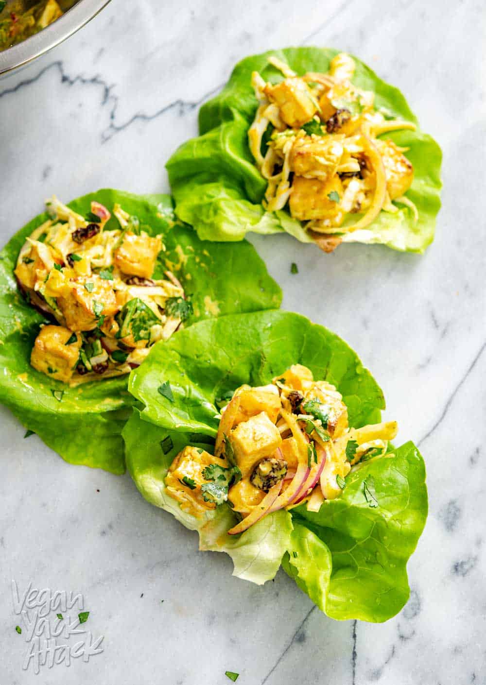 several curried tofu lettuce cups on a marble surface