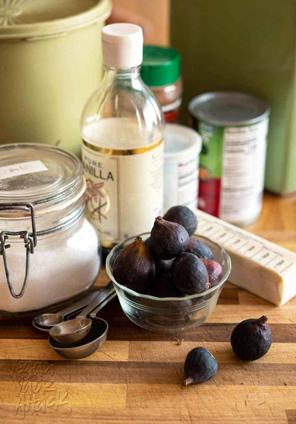 Figs, salt, vanilla, coconut milk, vegan butter, and more on a cutting board