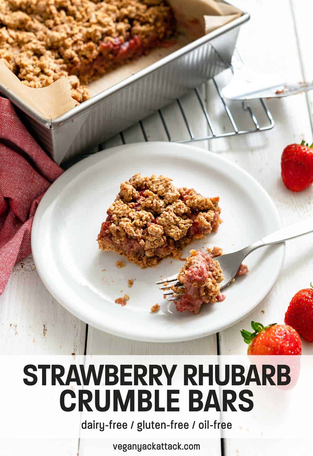 Piece of strawberry crumble bar cut out of a baking pan and bite on a fork next to it
