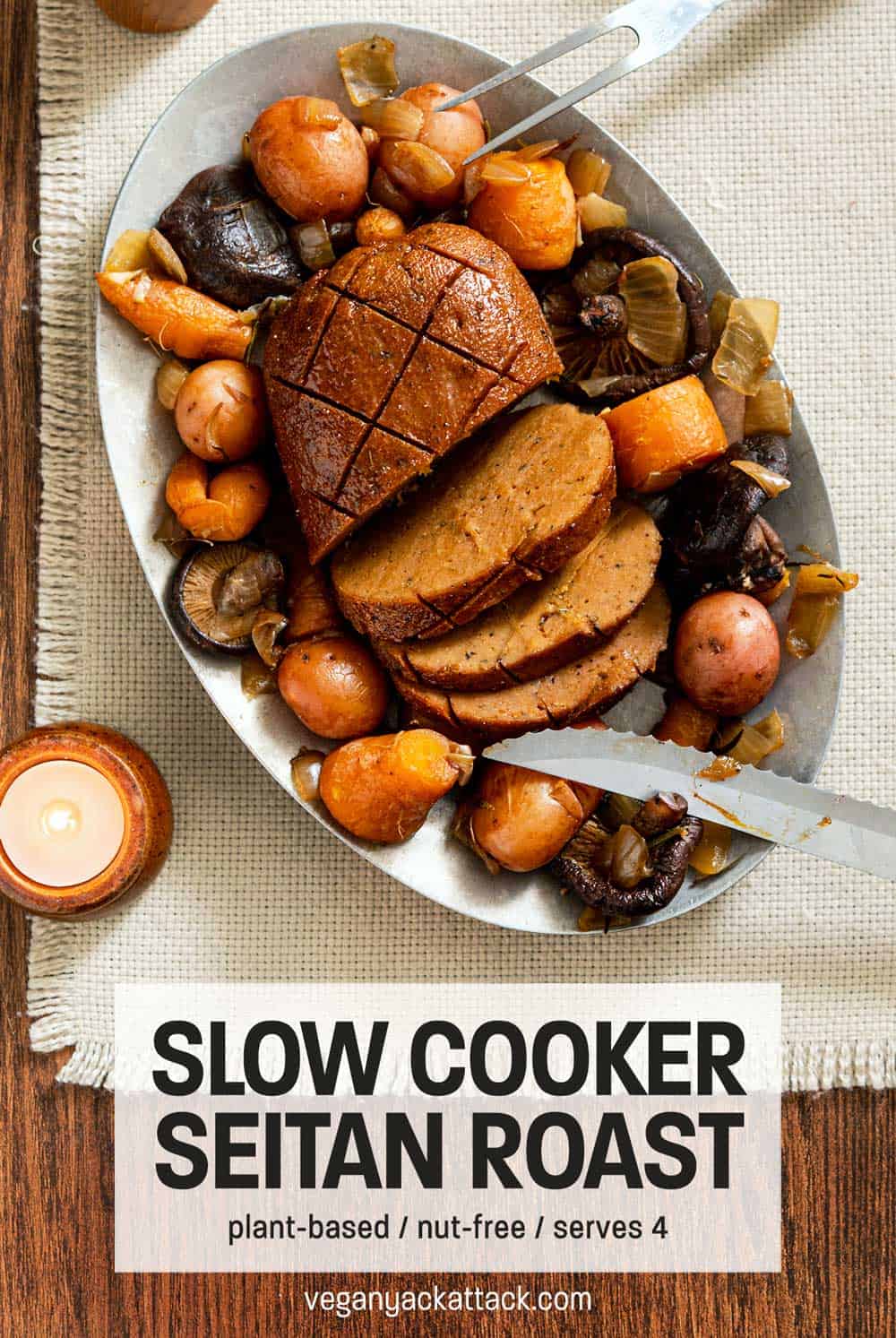 Sliced seitan roast on a metal platter with cooked vegetables