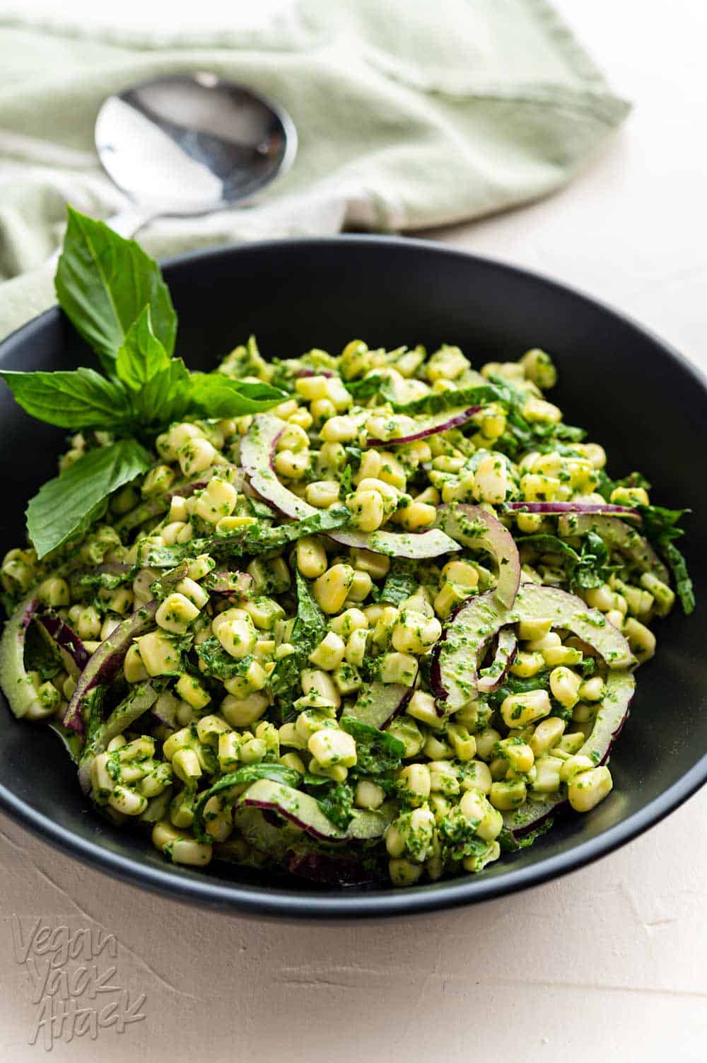 Close up of large black bowl filled with Summer corn salad and basil pesto aioli