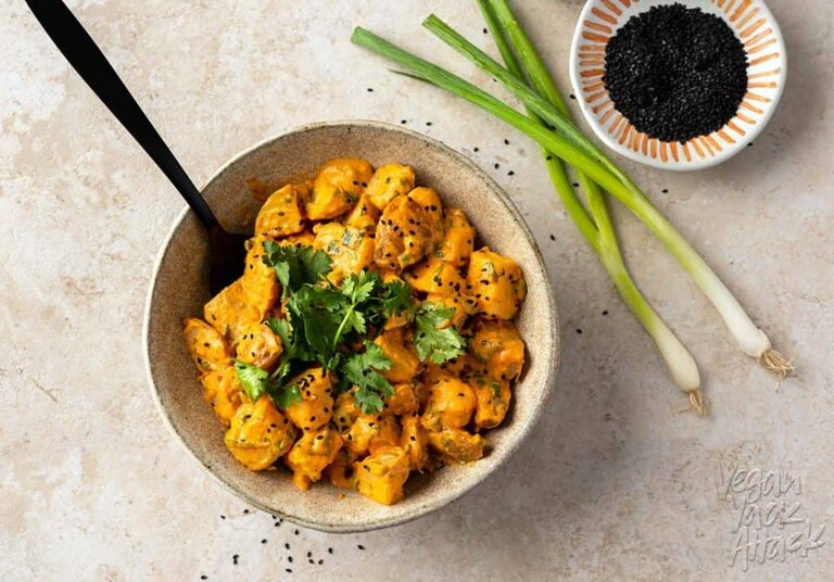 Large ceramic bowl filled with sriracha potato salad that is topped with sesame seeds and cilantro