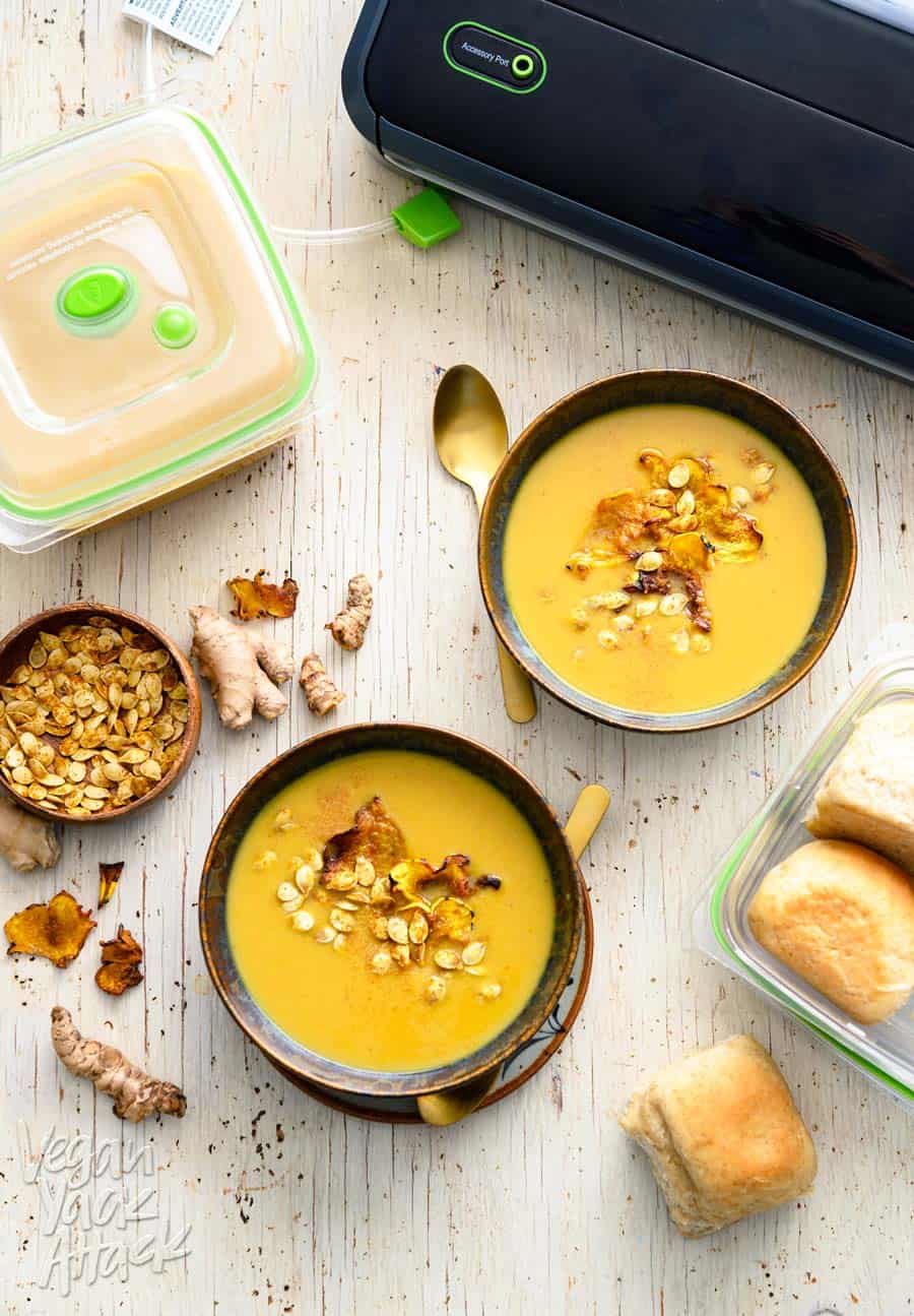 Two bowls of ginger turmeric squash soup with FoodSaver system and containers