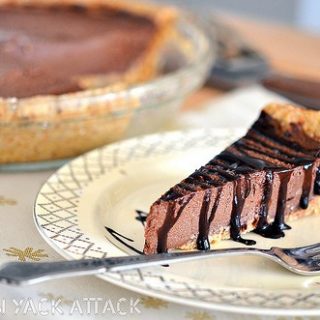 Slice of Raw Chocolate Mousse Pie with Chocolate Drizzle on a plate with fork
