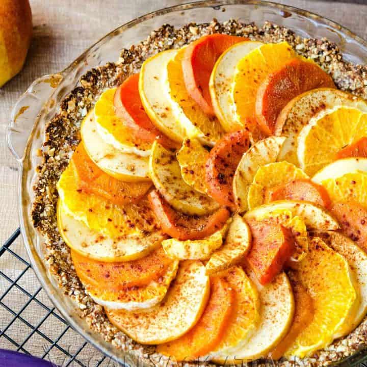 Layered fruit tart in a glass pie dish on a cooling rack