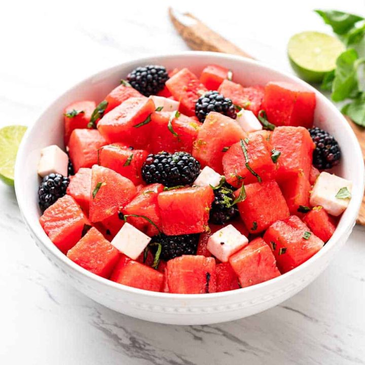 Watermelon Blackberry Feta Salad in a large white bowl with wooden tongs