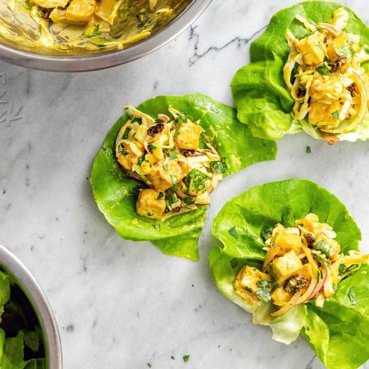 several curried tofu lettuce cups on a marble surface