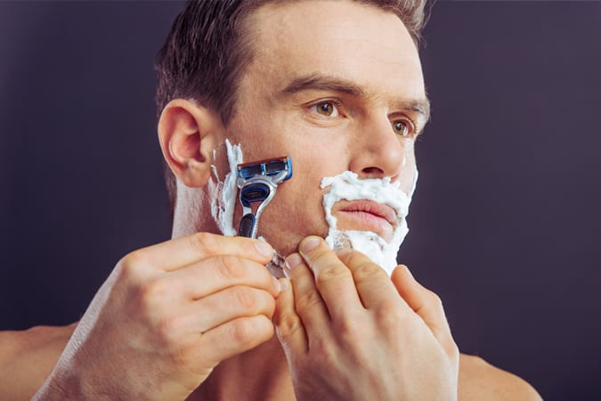 Man shaving in mirror
