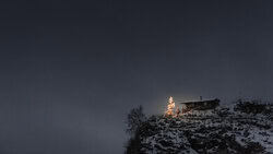 Wall art of a winter mountain village with festive lights under a dark sky