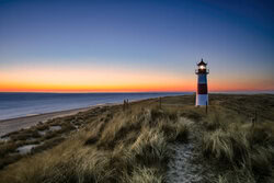Photo art: Lighthouse on Sylt's coastline at sunrise, calm atmosphere.