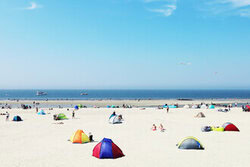 Buntes Sommerstrandleben mit Menschen, Boot und Zelt am Sandstrand